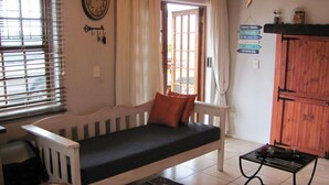 Une pièce chaleureuse avec un banc en bois, une horloge et un panneau indiquant différentes destinations de voyage.