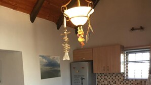 Une cuisine avec une table et un banc en bois, ainsi qu’un luminaire suspendu.