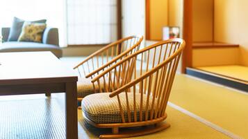 A traditional Japanese-style room with tatami flooring, a low wooden table, and two tatami mat chairs.