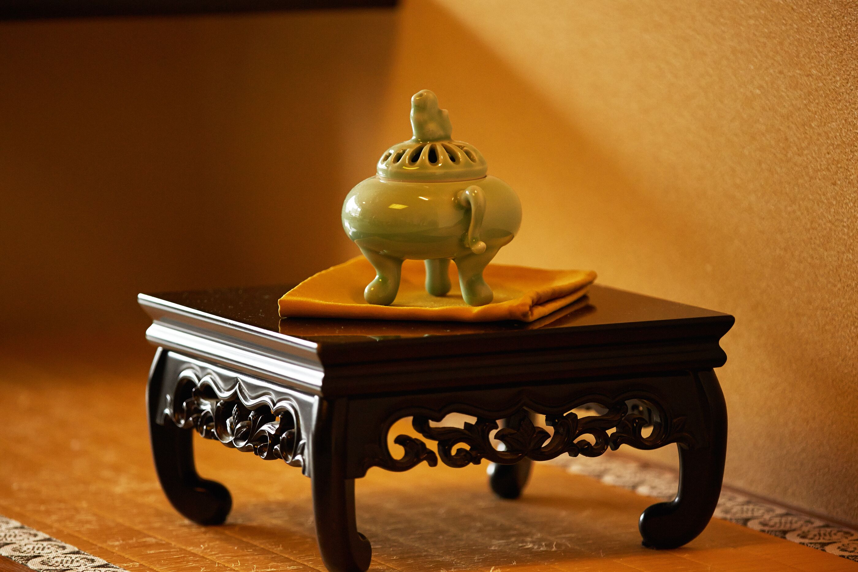 A small, ornate table with a decorative object on top.