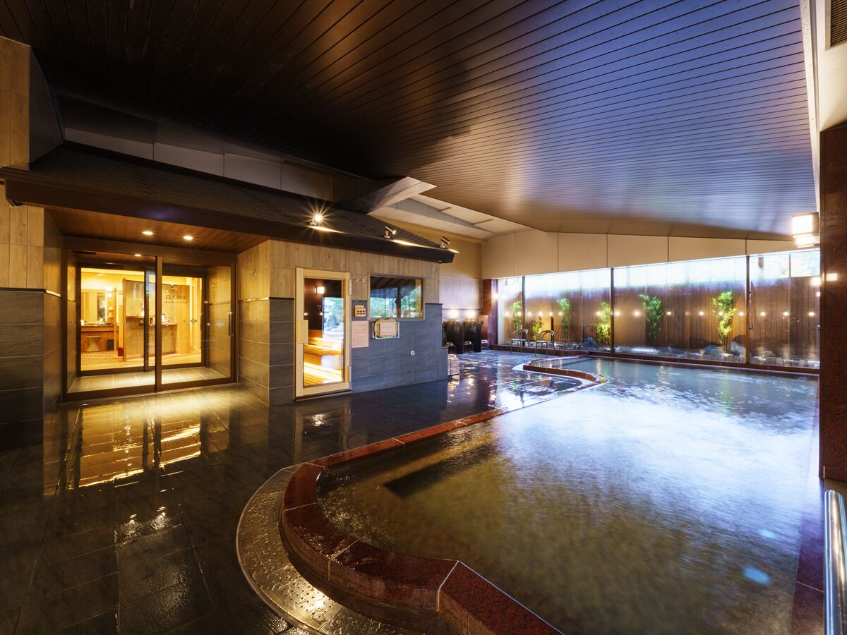 Un espacio de spa con hidromasaje, mostrador de recepción y vistas al exterior.