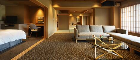 Ein Hotelzimmer mit Bett, einer Couch, einem Couchtisch und einem Fernseher.