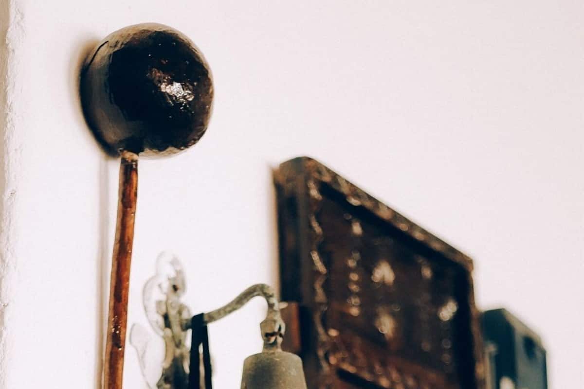 A wall-mounted bell, a framed picture, and a pair of binoculars.