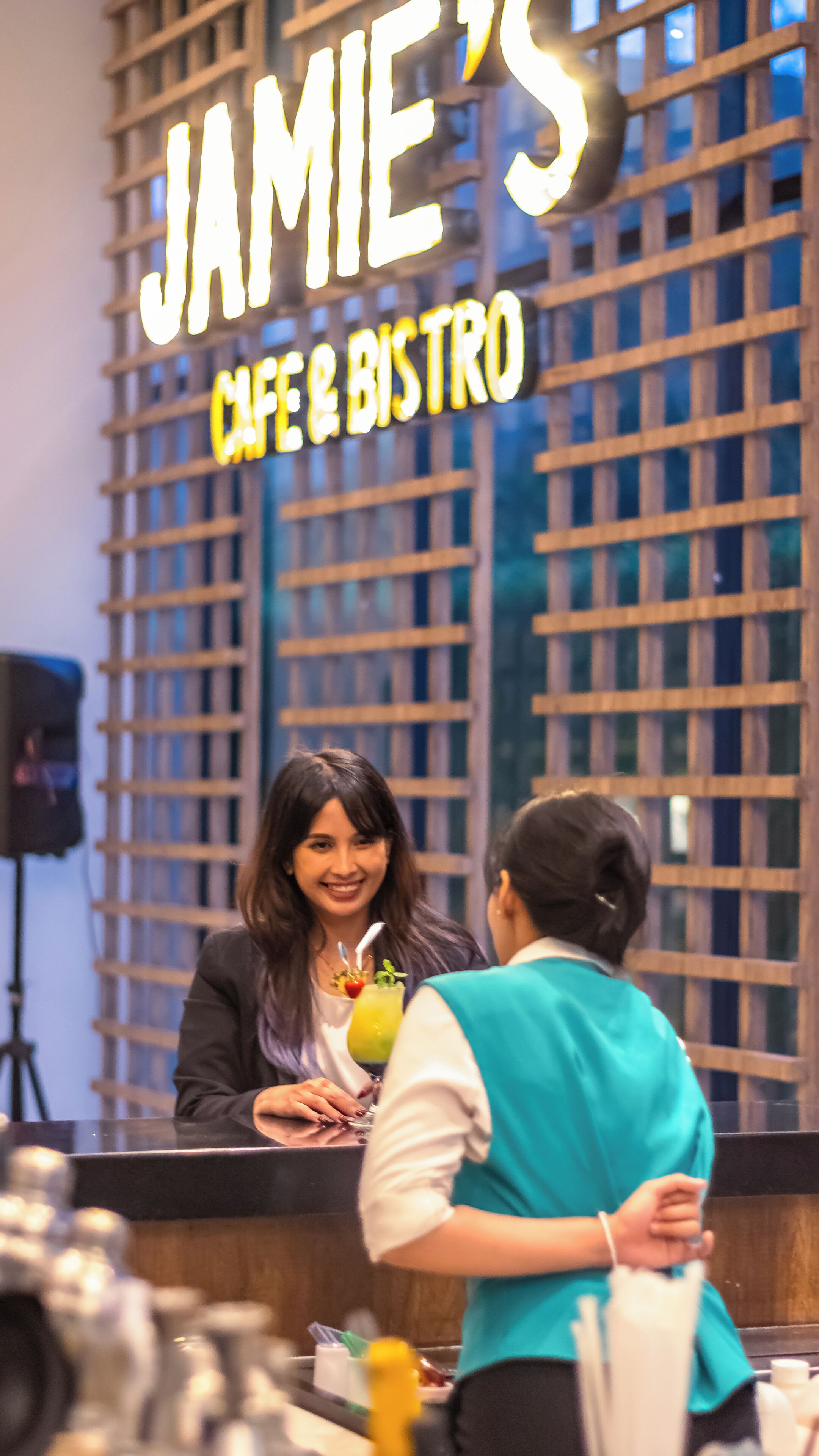 A cafe and bistro with a wooden lattice facade and a neon sign.