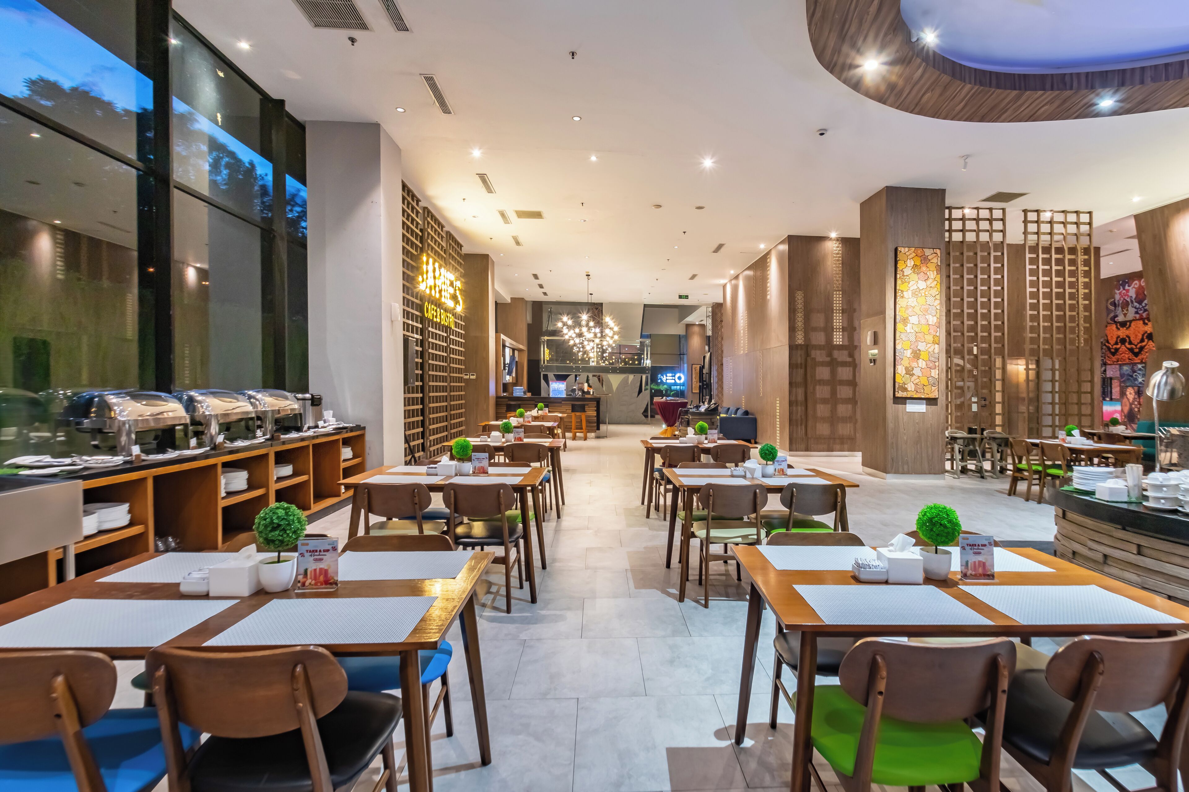 A modern restaurant with multiple dining areas, a buffet, and a bar.