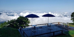 A deck with tables and chairs, overlooking a sea of clouds. - Pension COME (Minamiuonuma)