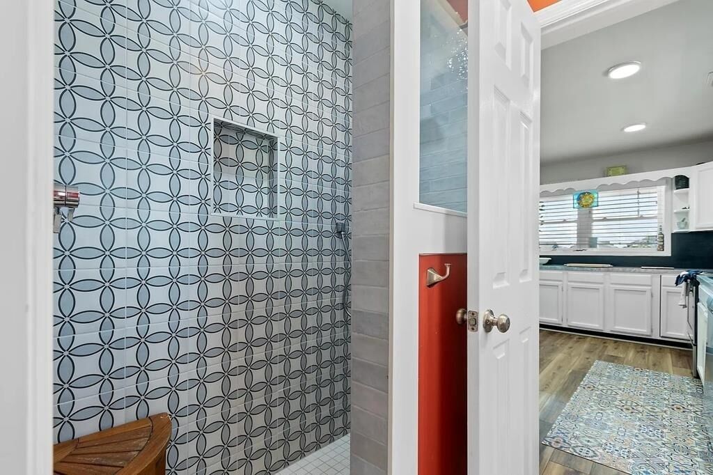 A modern kitchen with white cabinets and a patterned backsplash.
