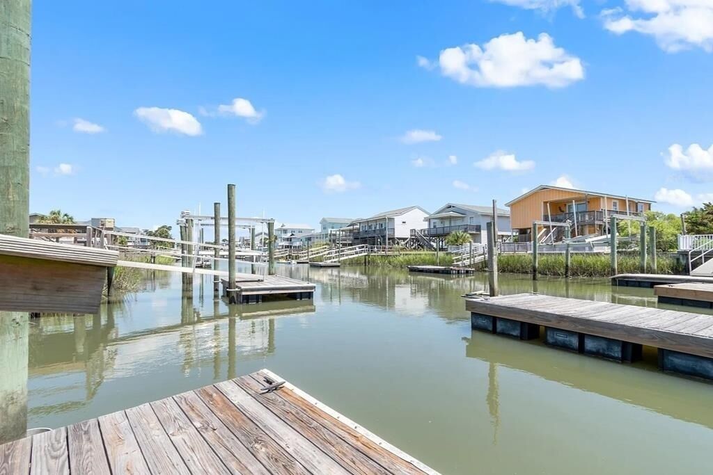 A waterfront property with wooden docks, a marina, and residential buildings.