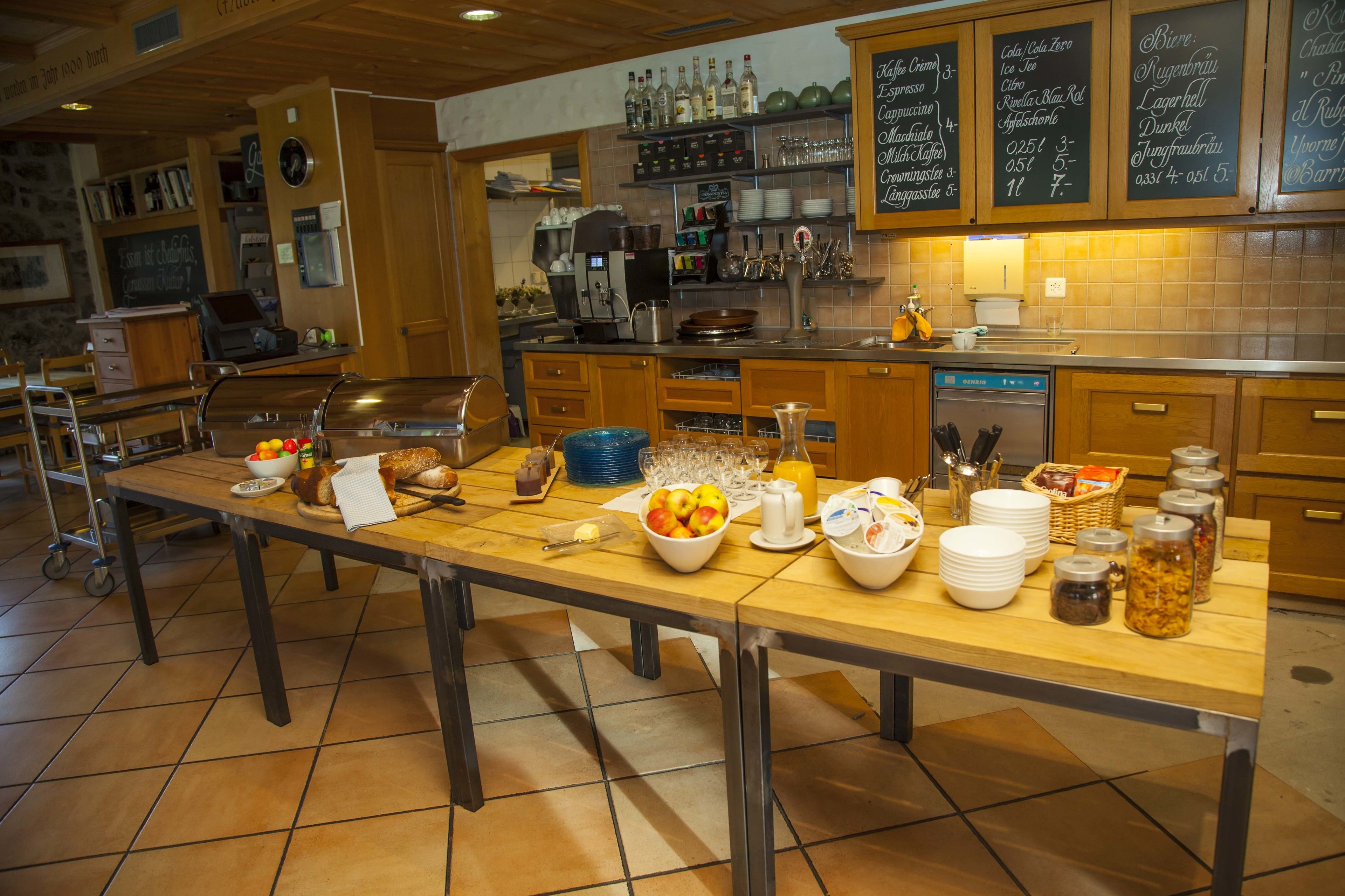 A kitchen with a long counter, various food items, and kitchen appliances.
