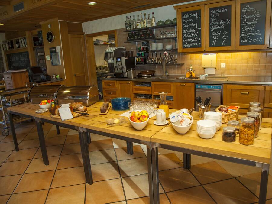 A kitchen with a long counter, various food items, and kitchen appliances.