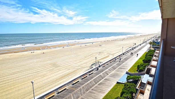 A beach view from a balcony with a wooden boardwalk, a promenade, and a clear sky. - Ocean Hideaway 503 (Ocean City)