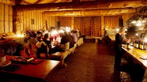 A rustic wooden interior with a stone floor, wooden tables, and a bar area. - Blåtind Apartments (Fjord)