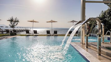 Una piscina cubierta, una piscina al aire libre, sombrillas, tumbonas