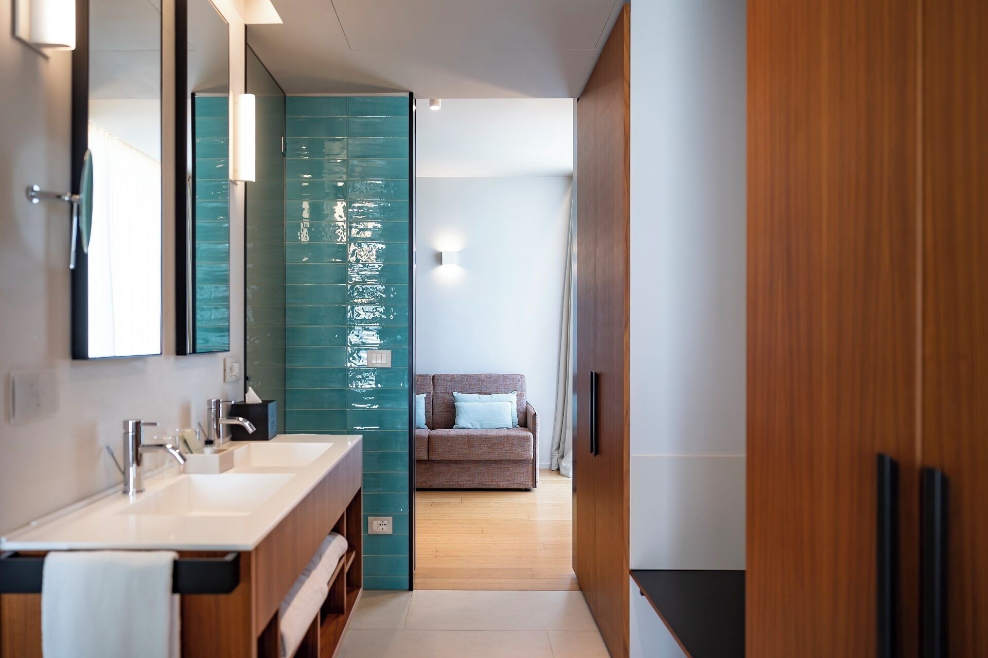 A modern bathroom with a large mirror, a sink, and a shower area.