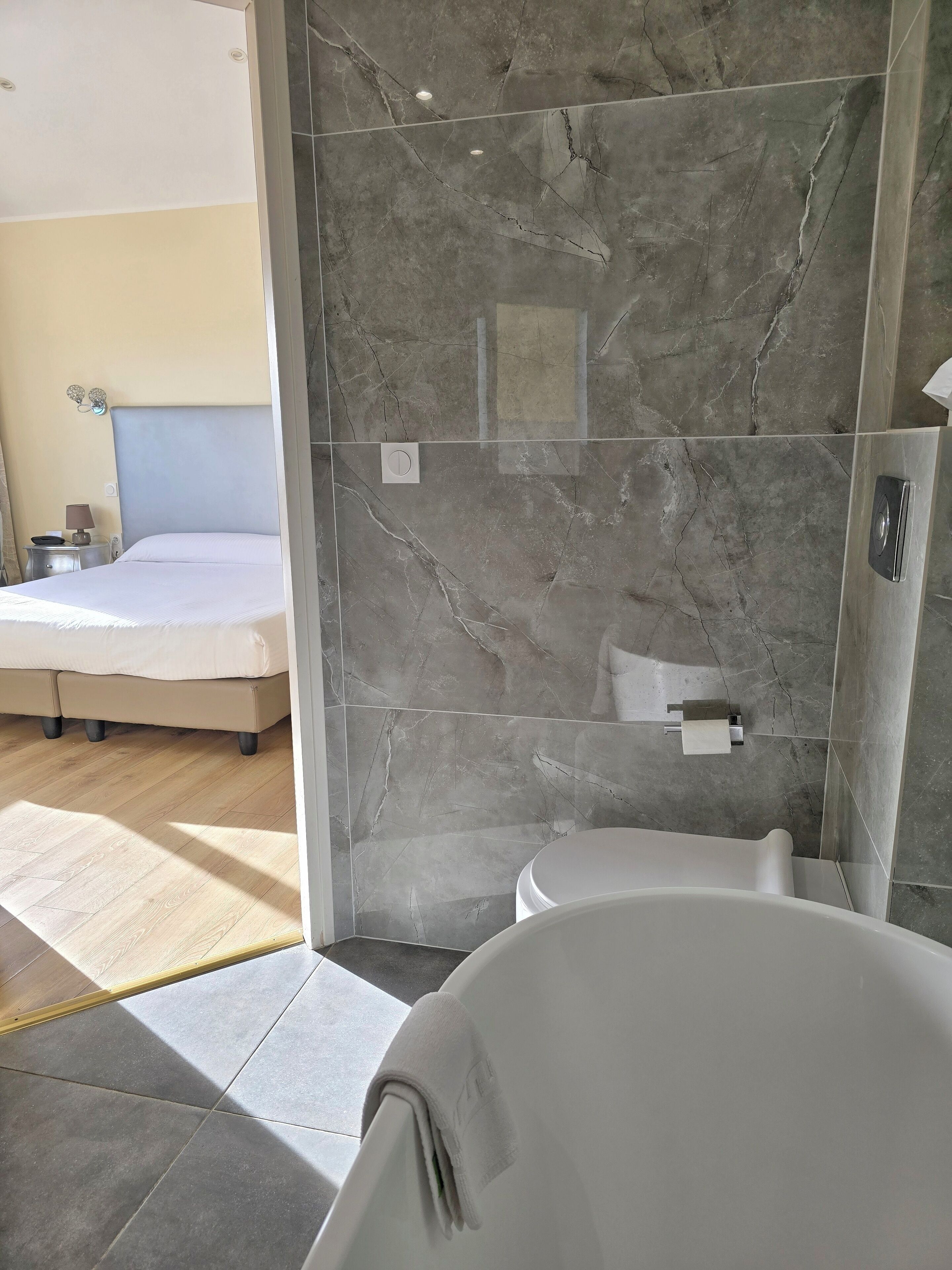 Ein modernes Badezimmer mit Badewanne, Toilette und Duschbereich.