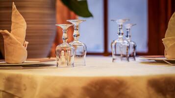 A table set with clear glassware and folded napkins, indicating a formal dining arrangement.