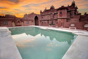 A large, rectangular pool with a clear reflection of the surrounding architecture.