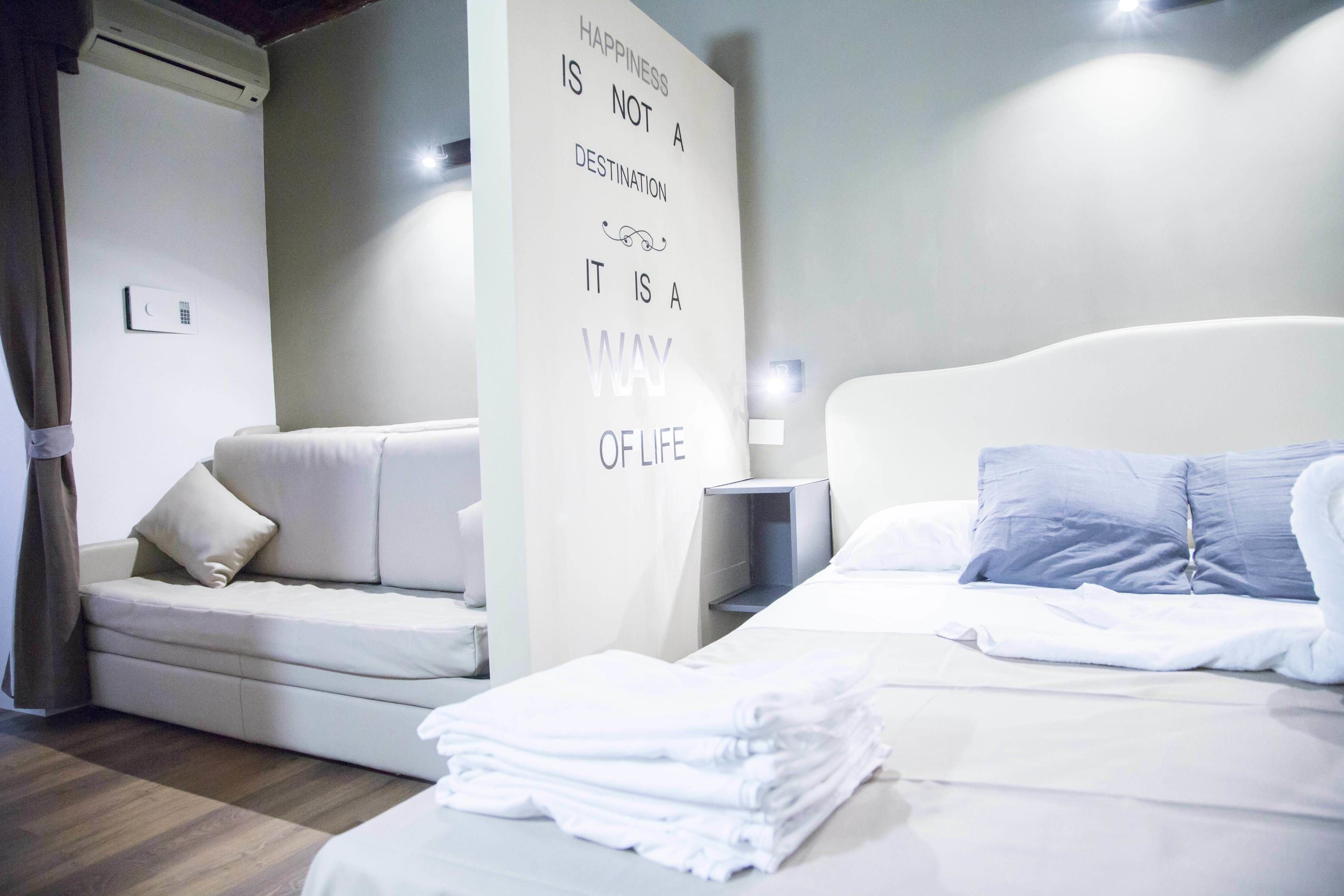 Una habitación de hotel moderna con una cama, un sofá y un letrero en la pared.