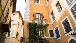 Eine enge Straße mit Gebäuden an beiden Seiten, mit Balkonen und Fenstern mit Fensterläden.