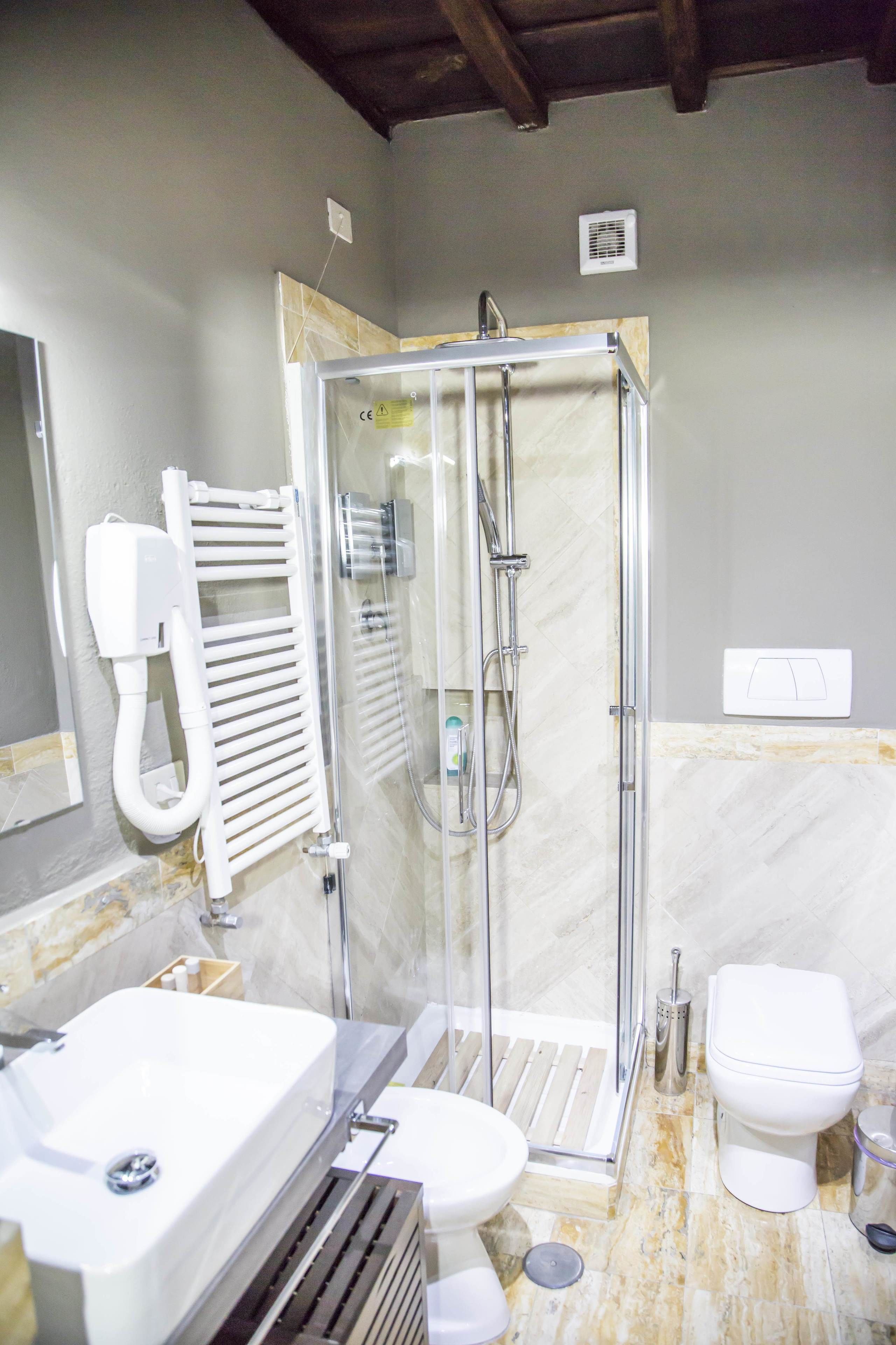 A bathroom with a shower, toilet, and sink.