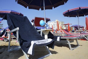 Plage, sable blanc, chaises longues, parasols