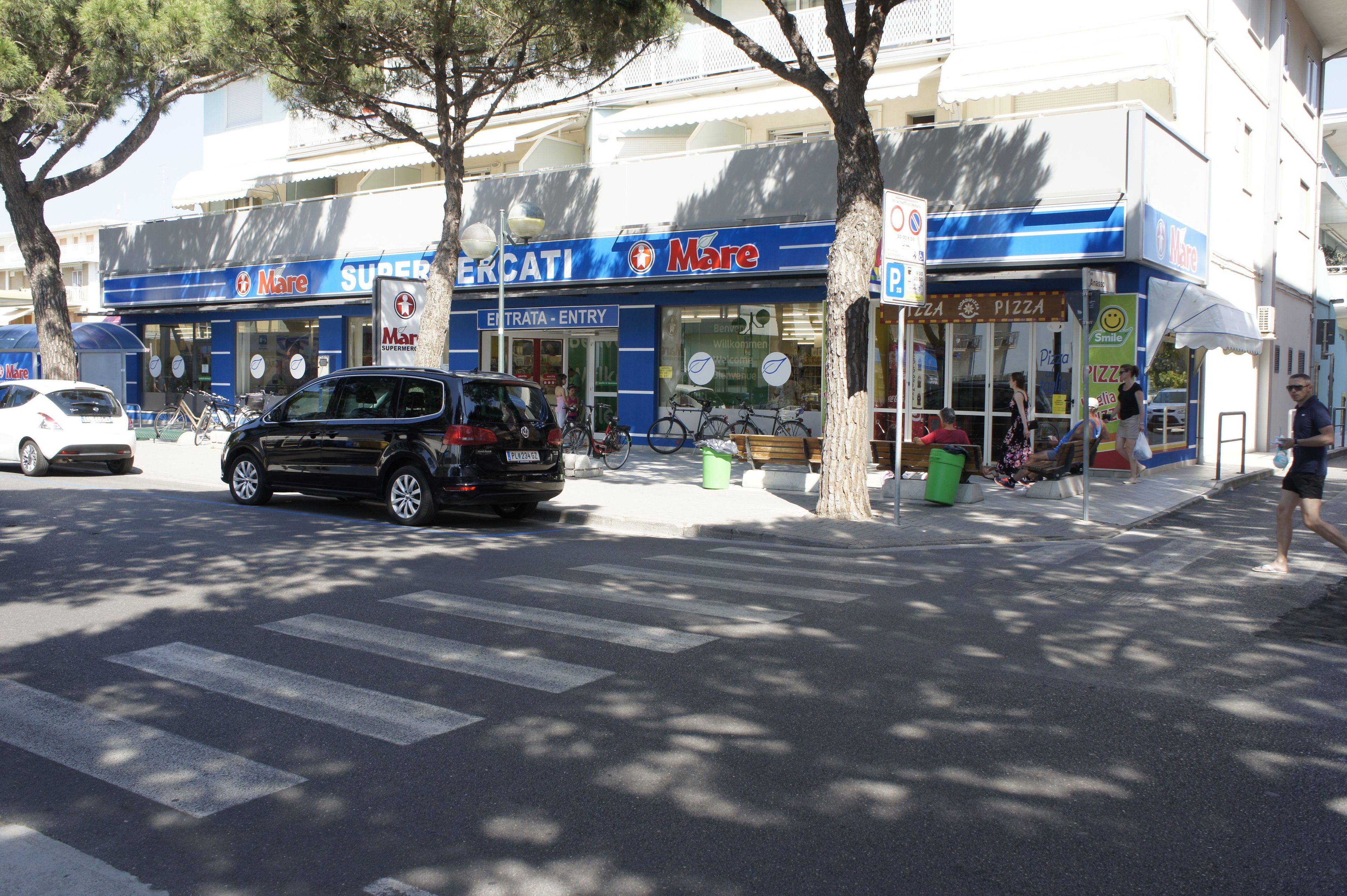 A street view with a pizza shop named 'Mare Supermercati' and a 'Pizza' sign.