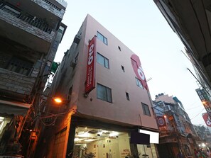 A multi-story building with a prominent sign for 'Hotel Aura Palace.'