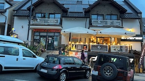 A building with a cafe named Rustica Cafe, featuring outdoor seating with umbrellas. - Villa Rustica (Solina)