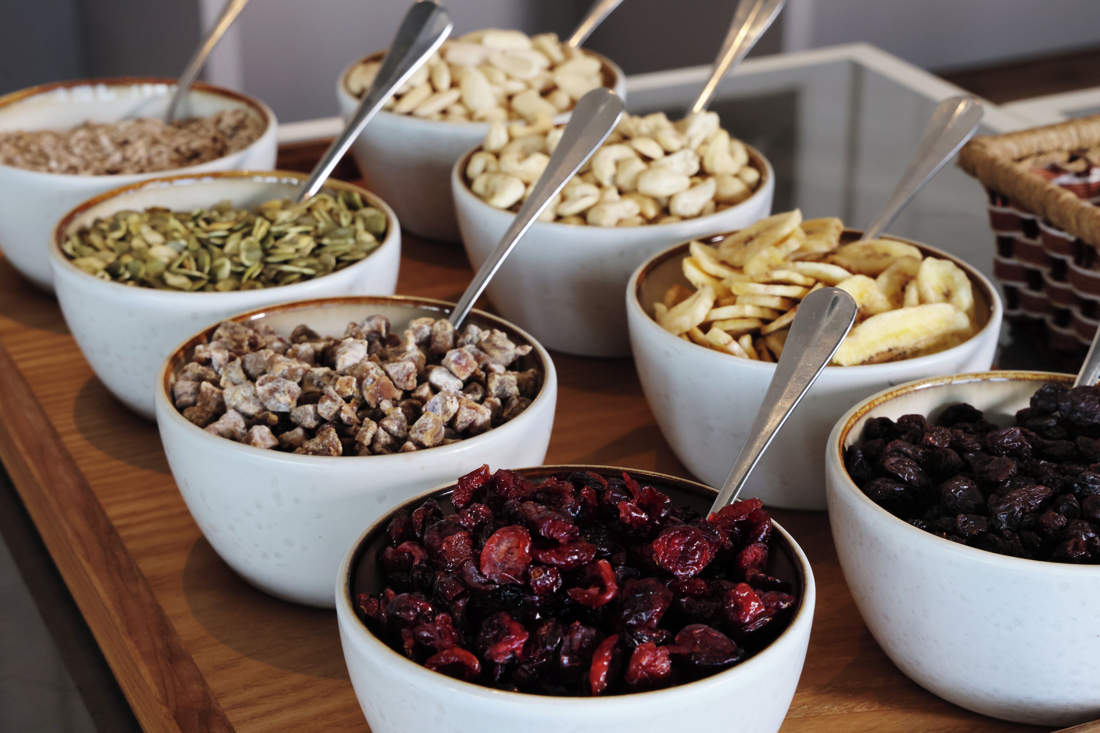 A variety of bowls containing different types of food items, each with a spoon.
