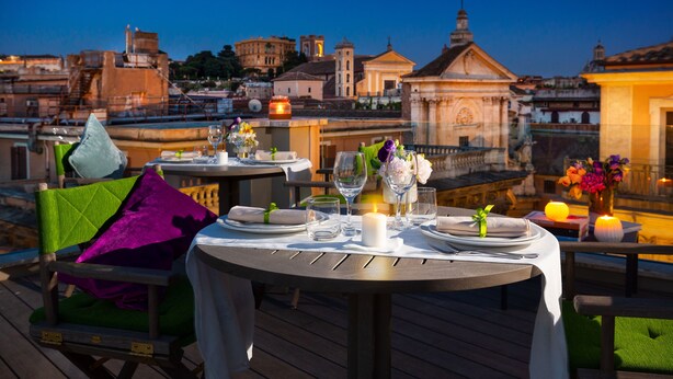 A dining table set for two with a view of historic buildings in the background.