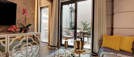 Una sala de estar moderna con sofá, mesa de centro, televisor y balcón con vistas.