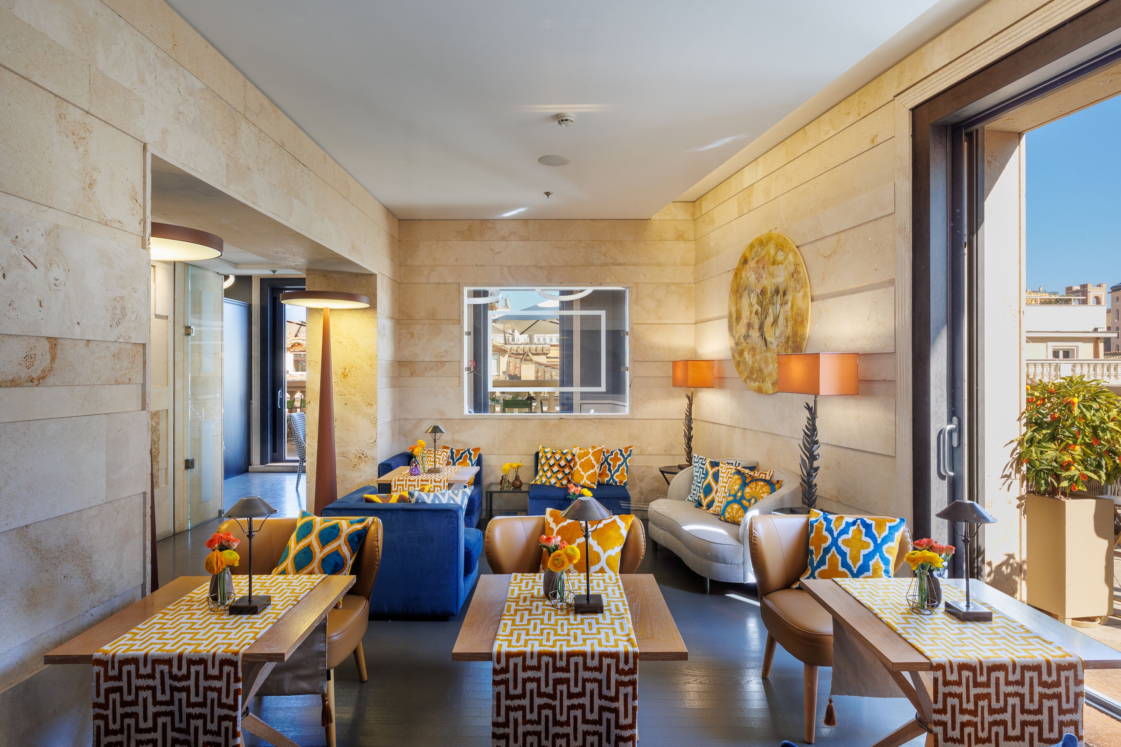 Un hall d’hôtel moderne doté d’un espace salon, d’une table basse et d’une grande fenêtre donnant sur la ville.
