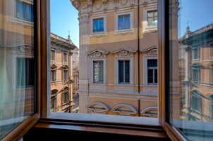 Vista dalla finestra di un edificio con dettagli architettonici elaborati, numerose finestre e balconi.