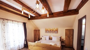 A bedroom with a wooden bed, a fur rug, wooden wardrobe, and a painting on the wall. - Casa Nitu (Întorsura Buzaului)