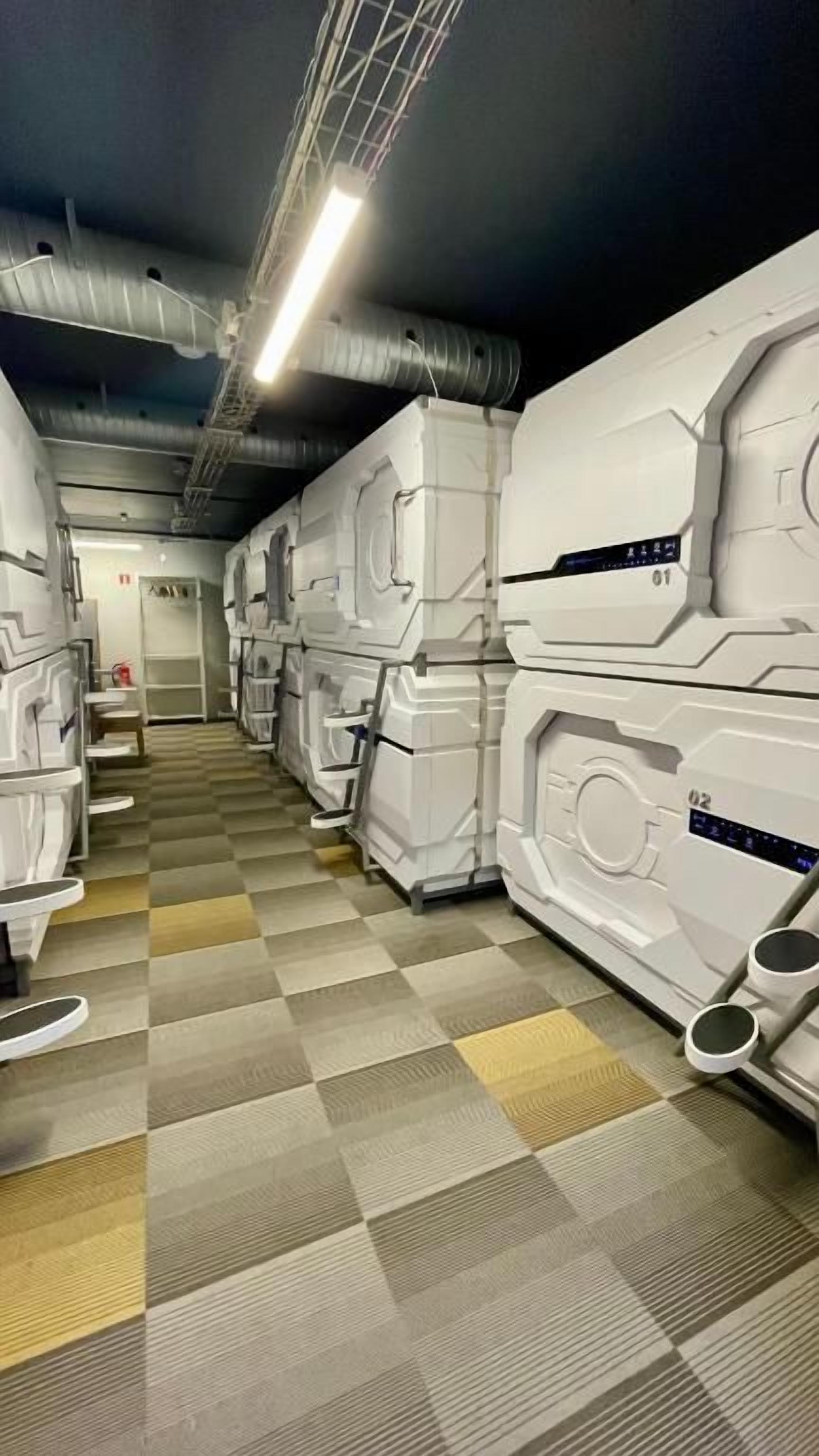 A corridor with rows of white, rectangular, and identical-looking units, possibly rooms or suites, with a checkered floor pattern.