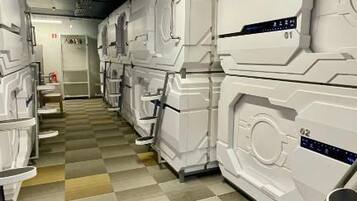 A corridor with rows of white, rectangular, and identical-looking units, possibly rooms or suites, with a checkered floor pattern.