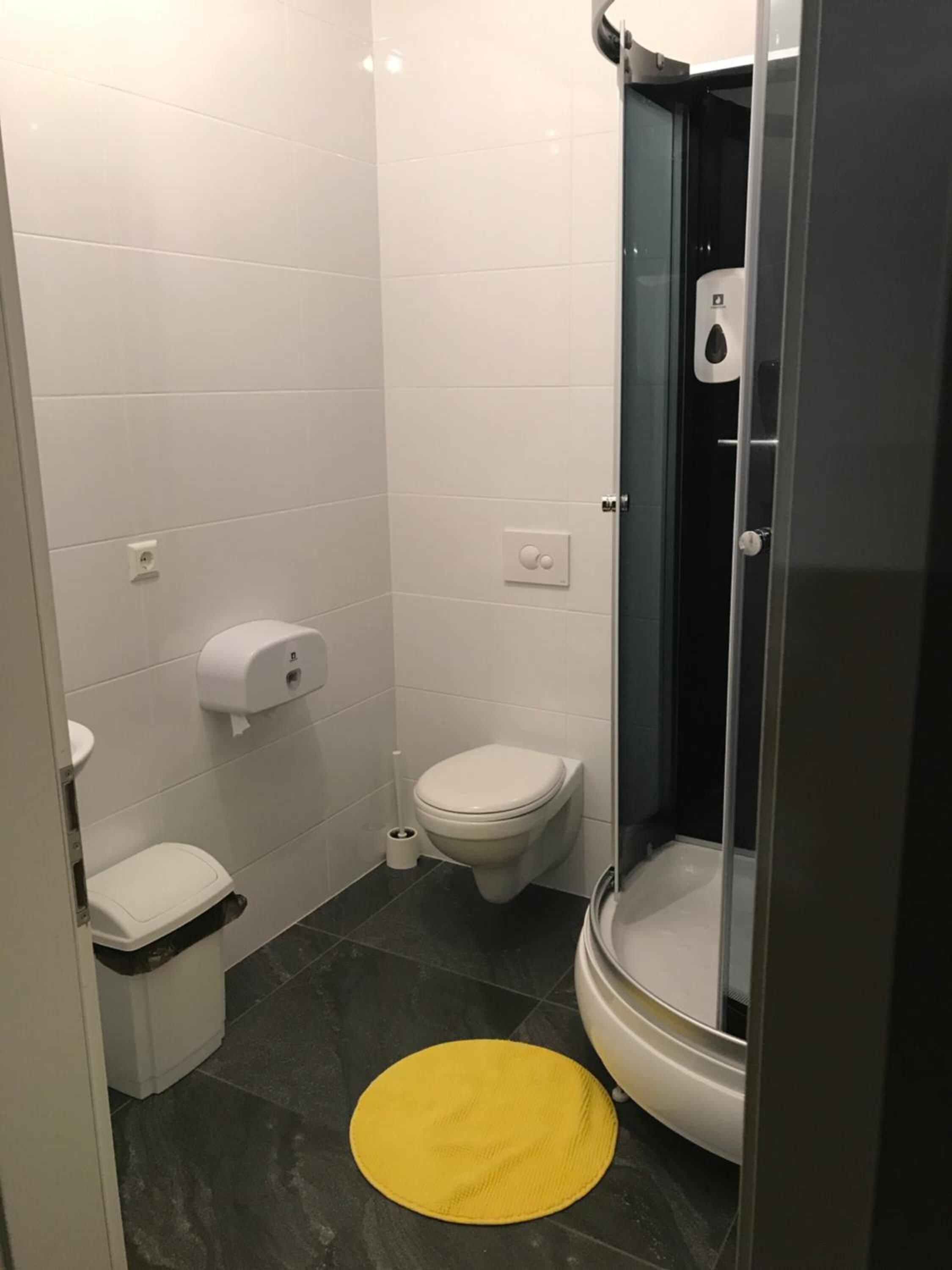 A small bathroom with a toilet, a bidet, and a shower stall.