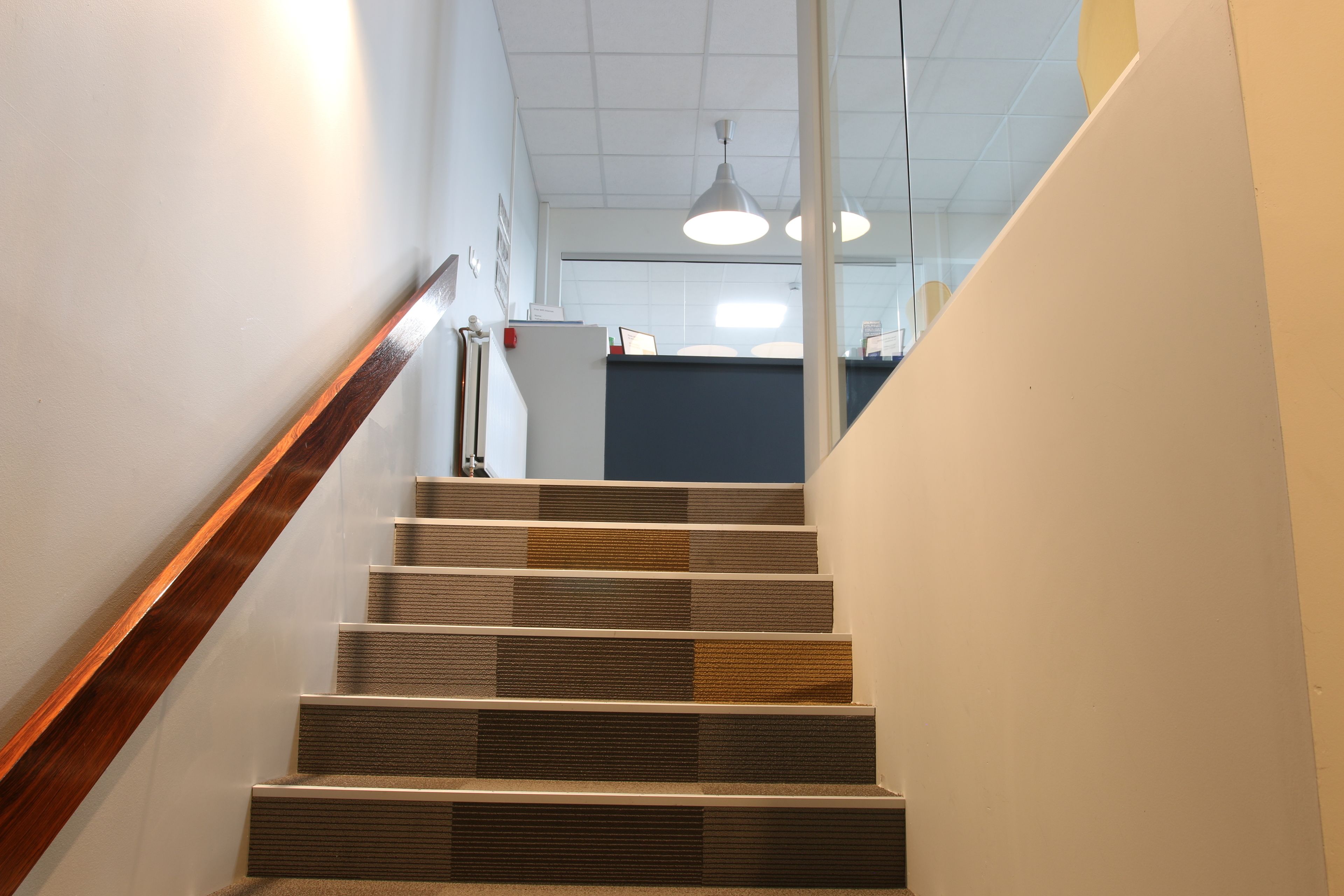 Una escalera con barandillas de madera y diseño moderno.