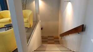 Una escalera con barandilla de madera y piso de patrones a cuadros.