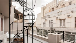 Una escalera en espiral en un edificio residencial con balcones y barandillas.