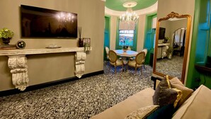 A dining area with a chandelier, a television, and a mirror. - Abbotsford Hotel (Ayr)