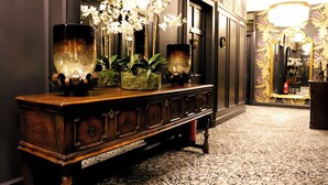 A grand hallway with a dark wooden console table, ornate mirror, and a patterned carpet. - Abbotsford Hotel (Ayr)