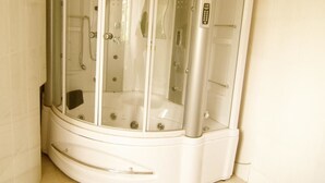A corner shower enclosure with a control panel and a glass door. - Star Hotel (Bujumbura)