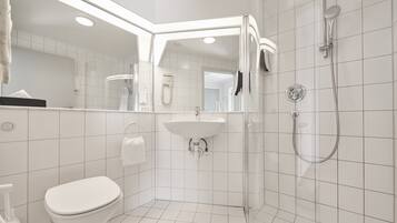 A modern bathroom with a toilet, sink, and shower area.