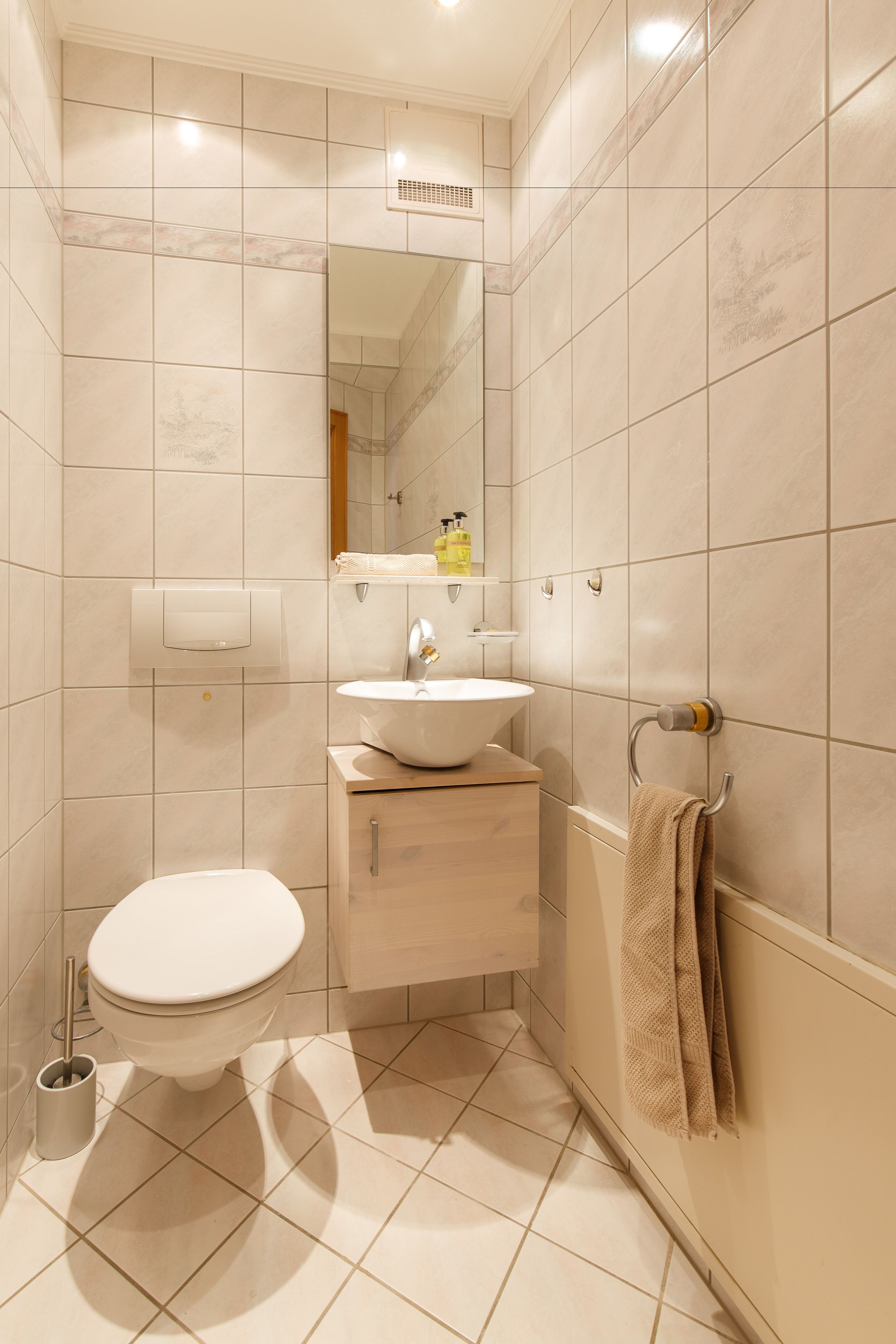 Une salle de bain moderne avec des toilettes, un lavabo et un miroir.