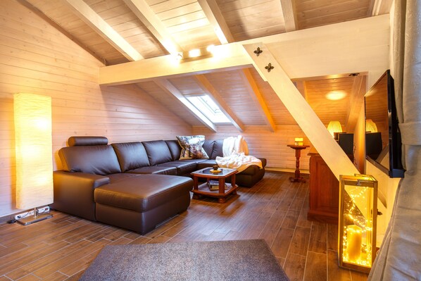 A cozy loft-style living room with a sectional sofa, a coffee table, and a TV. - BERGSUCHT-Ruhpolding (Ruhpolding)