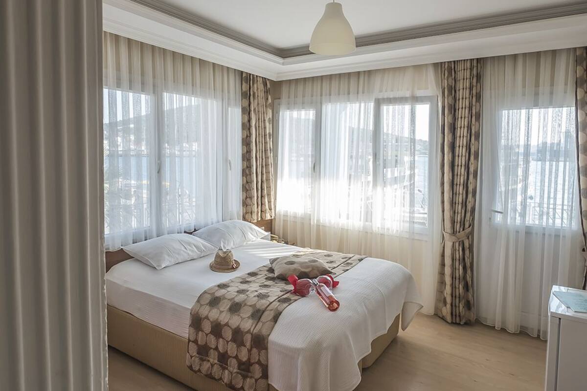 Hotellihuone, jossa on suuri sänky, punainen tuoli ja työpöytä.