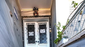 Un conjunto de escalones de mármol que conducen a una puerta blanca con paneles de vidrio decorativos.