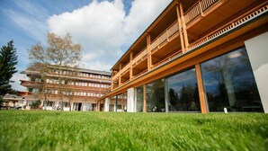 A modern building with a wooden balcony and large windows.