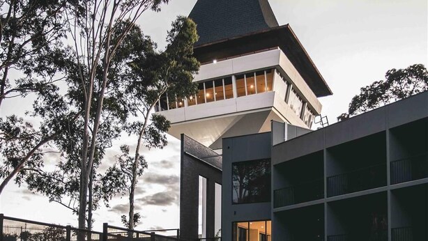 Un bâtiment moderne doté d’une tour imposante et de nombreux balcons.